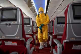 A man in protective suit works on disinfecting the aircraft cabin for a Hainan Airlines flight, as the country is hit by an outbreak of the novel coronavirus, at the Haikou Meilan International Airport in Haikou, Hainan province, China February 7, 2020.