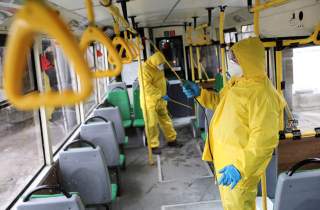Employees wearing protective gear spray disinfectant to sanitize a passenger bus as a preventive measure against the coronavirus in Lviv, Ukraine March 3, 2020. REUTERS/Mykola Tys