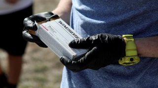 Firearms instructor Joseph Wilkey wears gloves while holding a box of 9mm Winchester ammunition during a firearms safety class conducted by Level Up Firearms amid fears of the global growth of coronavirus disease (COVID-19) cases, outside Loveland, Colora