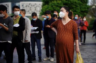 People wearing face masks line up outside Xianning Central Hospital in Xianning, after the lockdown was eased in Hubei province, the epicentre of China's coronavirus disease (COVID-19) outbreak, March 26, 2020. REUTERS/Aly Song