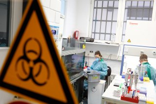 Employees in protective clothing perform tests for the corona virus at a laboratory in Berlin, Germany, March 26, 2020, as the spread of the coronavirus disease (COVID-19) continues. REUTERS/Axel Schmidt