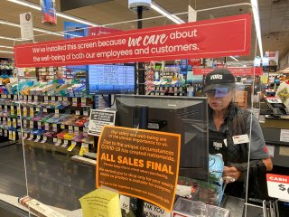 A grocery store worker is protected by a shield at a Vons store during the outbreak of the coronavirus disease (COVID-19) in Solana Beach, California, U.S., March 29, 2020. REUTERS/Mike Blake