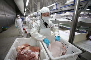 Employees work at a pig slaughtering and pork processing plant in Huaian, Jiangsu province, China April 9, 2020. Picture taken April 9, 2020. China Daily via REUTERS