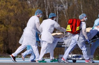 French rescue team wearing protective suits carry a patient on a stretcher from Mulhouse hospital before being loaded into a helicopter as France faces an aggressive progression of the coronavirus disease (COVID-19), March 23, 2020. REUTERS/Christian Hart