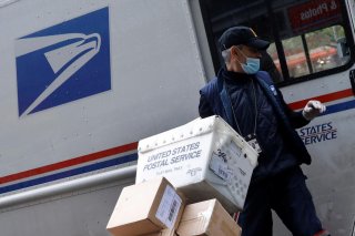 A United States Postal Service (USPS) worker unloads packages from his truck in Manhattan during the outbreak of the coronavirus disease (COVID-19) in New York City, New York, U.S., April 13, 2020. REUTERS/Mike Segar