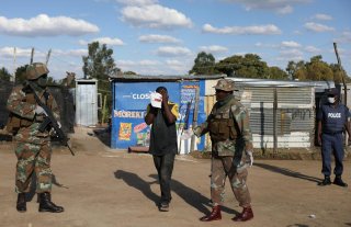 Soldiers on patrol interogates a resident amid the spread of the coronavirus disease (COVID-19) continues in Diepsloot, a shantytown north of Johannesburg, South Africa, April 16, 2020. REUTERS/Siphiwe Sibeko