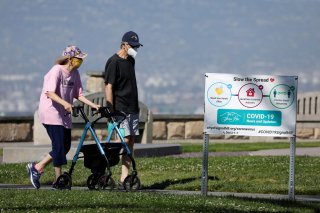 An elderly couple wear masks as they get some exercise in a park during the outbreak of the coronavirus disease (COVID-19) in Signal Hill, California, U.S., April 23, 2020. REUTERS/Mike Blake