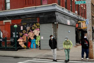 Pedestrians wearing masks walk in front of shuttered buildings as the spread of the coronavirus disease (COVID-19) outbreak continues in the Brooklyn borough of New York City, U.S., April 27, 2020. REUTERS/Lucas Jackson