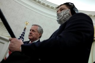 White House Acting Chief of Staff Mark Meadows listens next to a masked soundman and member of the news media during U.S. President Donald Trump's coronavirus response meeting with New Jersey Governor Phil Murphy in the Oval Office at the White House in W