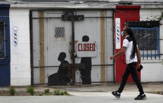 A pedestrian walks past a closed barber shop in Ward 7 as the coronavirus disease (COVID-19) outbreak continues in Washington, U.S., May 8, 2020. REUTERS/Leah Millis