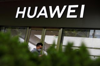 A man in a face mask walks past a Huawei shop, amid an outbreak of the coronavirus disease (COVID-19), in Beijing, China, May 18, 2020. REUTERS/Thomas Peter