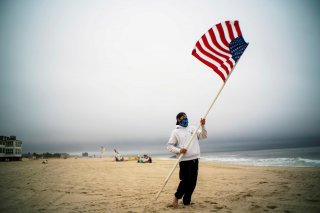 A beach guard removes the U.S. flag of his spot after a day of duty at Long Branch beach after New Jersey beaches were opened ahead of the Memorial Day weekend following the outbreak of the coronavirus disease (COVID-19) in Long Branch, New Jersey, U.S., 