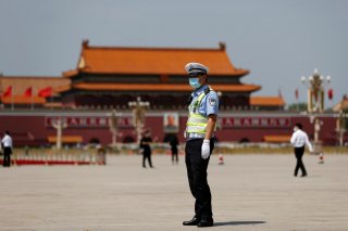 A police officer wearing a face mask following the coronavirus disease (COVID-19) outbreak stands on Tiananmen Square before the closing session of the National People's Congress (NPC) in Beijing, China May 28, 2020. REUTERS/Carlos Garcia Rawlins