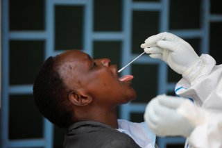 A health worker takes a swab from a woman during mass testing in an effort to stop the spread of the coronavirus disease (COVID-19), in Nairobi, Kenya May 28, 2020. REUTERS/Baz Ratner