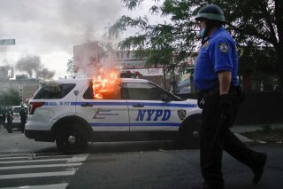 A NYPD police car is sets on fire as protesters clash with police during a march against the death in Minneapolis police custody of George Floyd, in the Brooklyn borough of New York City, U.S., May 30, 2020. REUTERS/Eduardo Munoz