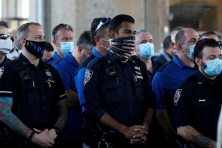 Uniformed officers wear protective face masks as they listen while Police Benevolent Association of the City of New York President Pat Lynch speaks as he and representatives from other New York City Police Department (NYPD) and law enforcement unions hold