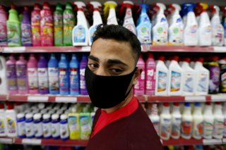 A Palestinian man wearing a mask looks on as he stands in front of disinfectants and cleaning products in a supermarket amid the coronavirus disease (COVID-19) crisis, in the southern Gaza Strip June 9, 2020. REUTERS/Ibraheem Abu Mustafa