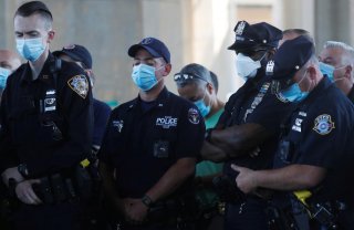 Uniformed officers wear protective face masks as they listen while Police Benevolent Association of the City of New York President Pat Lynch speaks as he and representatives from other New York City Police Department (NYPD) and law enforcement unions hold