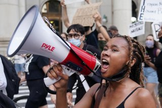 People protest in the street outside a protest to defund the police in a place they are calling the 