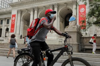 A large mask hangs on the face of a lion statue standing outside of the main branch of the New York Public Library in the Manhattan borough of New York City, U.S., July 1, 2020. REUTERS/Lucas Jackson