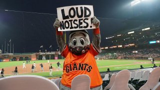 Jul 28, 2020; San Francisco, California, USA; San Francisco Giants mascot Lou Seal holds a sign reading Òloud noises!Ó during the sixth inning against the San Diego Padres at Oracle Park. Mandatory Credit: Kelley L Cox-USA TODAY Sports