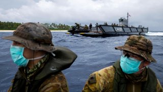 Australian Army soldiers from 2nd Battalion, the Royal Australian Regiment, launch a zodiac inflatable boat from one of HMAS Canberra's Landing Craft to deliver food and supplies to three stranded mariners from the Federated States of Micronesia following