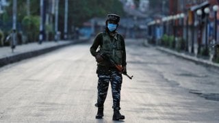 An Indian Central Reserve Police Force (CRPF) officer patrols on an empty street during a lockdown on the first anniversary of the revocation of Kashmir's autonomy, in Srinagar August 5, 2020. REUTERS/Danish Ismail/