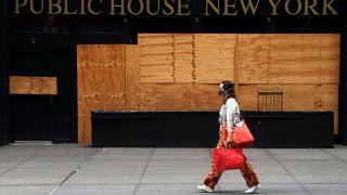 A woman walks past a shuttered bar following the coronavirus (COVID-19) disease outbreak in the Manhattan borough of New York City, New York, U.S., August 7, 2020. REUTERS/Carlo Allegri