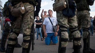 People talk to Belarusian law enforcement officers near the site where a protester died on August 10 during a rally following the presidential election in Minsk, Belarus August 11, 2020. REUTERS/Stringer