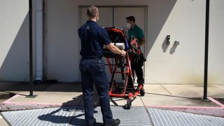 Orion EMS employees wheel a stretcher into the Houston Methodist Emergency Care Center at Kirby while wearing protective equipment to prevent the spread of the coronavirus disease (COVID-19) in Houston, Texas, U.S., August 19, 2020. REUTERS/Callaghan O'Ha