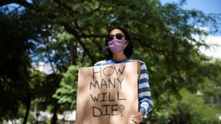 Faculty member protests in-person classes for fall semester amid the coronavirus disease (COVID-19) pandemic, outside Fleming Administrative Building at the University of Michigan campus in Ann Arbor, Michigan, U.S., August 19, 2020. REUTERS/Emily Elconin