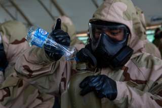 U.S. Marine Corps Cpl. Anthony Calderon, a systems administrator attached to Special Purpose Marine Air Ground Task Force Crisis Response-Central Command, fills his canteen during chemical, biological, radiological and nuclear defense training in Kuwait, 