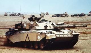 A British Challenger main battle tank, the squadron leader of D Sqn, Royal Scots Dragoon Guards, moves into a base camp along with other Allied armor during Operation Desert Storm.