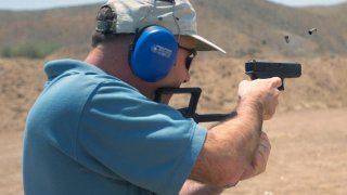 US Marine Corps Colonel James Cooney, Commander, Marine Corps Air Station Yuma, Arizona, fires a 9mm Glock 18 machine pistol while attending a period foreign military small arms weapons course at Adair MCAS) Yuma, Arizona. U.S. Marine Corps.