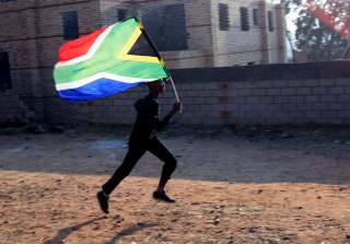 A worker runs with the South African flag inside the Soccer City stadium in Soweto, Johannesburg June 10, 2010. The stadium will host the opening and final games of the 2010 FIFA Soccer World Cup which kicks off on June 11. REUTERS/Radu Sigheti (SOUTH AFR