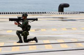 A soldier stands guard with his weapon during the 2011 Jinhua exercise at the Port of Taipei in New Taipei City, northern Taiwan, June 29, 2011. Taiwan on Wednesday hosted a disaster and anti-terrorism drill that involved more than 1000 people from the po