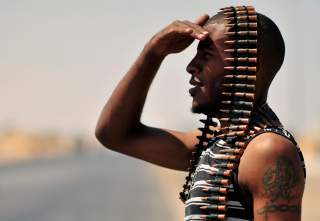 A Libyan rebel stands guard near the entrance of Ras Lanuf August 27, 2011. REUTERS/Esam Al-Fetori (LIBYA - Tags: POLITICS CIVIL UNREST TPX IMAGES OF THE DAY CONFLICT)