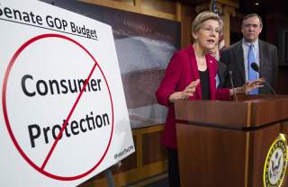 Senators Elizabeth Warren (D-MA), Al Franken (hidden)(D-MN) and Jeff Merkley (D-OR) hold a news conference to warn about the abolishment of Consumer Financial Protection Bureau in the proposed budget put forward by Senate Republicans on Capitol Hill