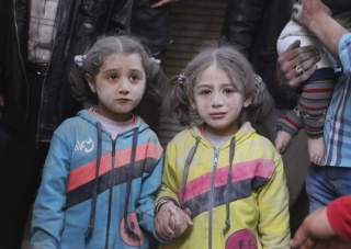 Girls who survived what activists said was a ground-to-ground missile attack by forces of Syria's President Bashar al-Assad, hold hands at Aleppo's Bab al-Hadeed district April 7, 2015. REUTERS/Abdalrhman Ismail TPX IMAGES OF THE DAY