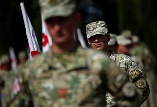 Soldiers stand at attention during a ceremony at the memorial cemetery of the Georgian soldiers killed during the war with Russia over the breakaway region of South Ossetia in 2008 in Tbilisi, Georgia, August 8, 2017. REUTERS/David Mdzinarishvili