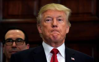 With Treasury Secretary Steve Mnuchin standing behind him, U.S. President Donald Trump listens to remarks before signing an executive order, making it easier for Americans to buy bare-bone health insurance plans and circumvent Obamacare rules.