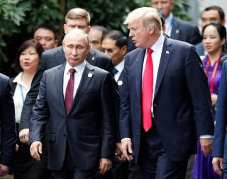 U.S. President Donald Trump and Russia's President Vladimir Putin talk during the family photo session at the APEC Summit in Danang, Vietnam November 11, 2017.