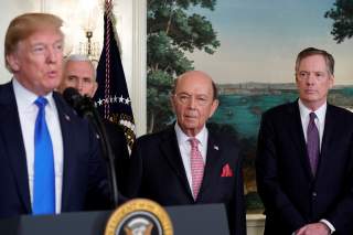 U.S. President Donald Trump, flanked by ?Vice President Mike Pence?, Commerce Secretary Wilbur Ross and U.S. Trade Representative Robert Lighthizer, delivers remarks before signing a memorandum on intellectual property tariffs on high-tech goods from Chin