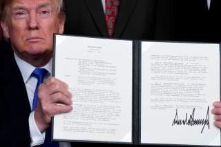 U.S. President Donald Trump holds a signed memorandum on intellectual property tariffs on high-tech goods from China, at the White House in Washington, U.S. March 22, 2018. REUTERS/Jonathan Ernst