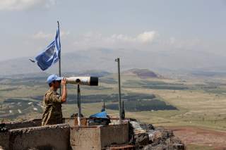 A United Nations Truce Supervision Organisation military observer uses binoculars near the border with Syria in the Israeli-occupied Golan Heights, Israel May 11, 2018. REUTERS/Baz Ratner