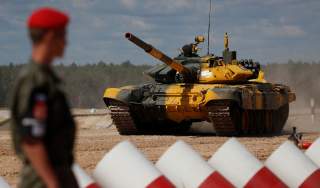 A Russian military police officer stands guard in front of a T-72 B3 tank operated by a crew from Venezuela during the Tank Biathlon competition at the International Army Games 2018 in Alabino outside Moscow, Russia August 8, 2018. REUTERS/Maxim Shemetov