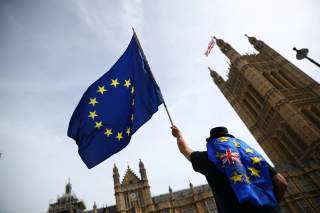 An anti-Brexit demonstrator waves flags outside the Houses of Parliament, in London, Britain, September 10, 2018. REUTERS/Hannah McKay