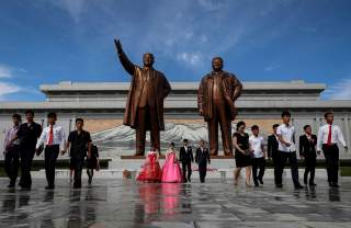 A couple with their friends and families leave after paying their respects in front of bronze statues of the late leaders Kim Il Sung and Kim Jong Il before getting married in Pyongyang, North Korea, September 11, 2018. REUTERS/Danish Siddiqui