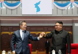 South Korean President Moon Jae-in and North Korean leader Kim Jong Un hold hands after watching the performance titled 