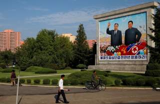 Residents pass by a painting of late North Korean leaders Kim Il Sung and Kim Jong Il in Pyongyang, North Korea, September 6, 2018. REUTERS/Danish Siddiqui 